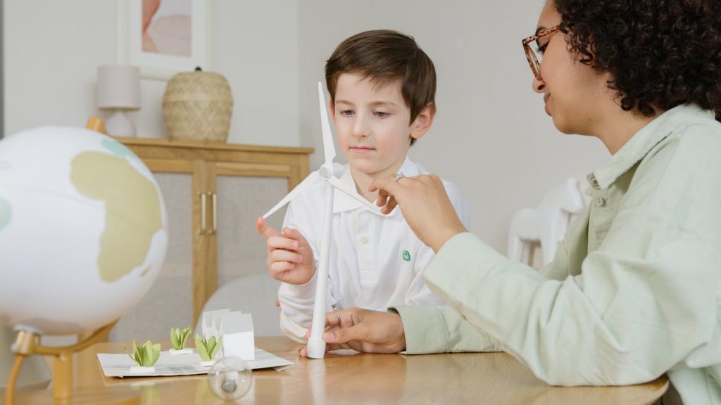 pexels photo 6990472 A boy and teacher exploring a wind turbine model, promoting environmental education.
