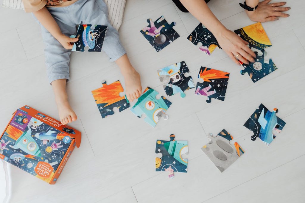 pexels photo 7269489 Overhead shot of children solving a colorful space-themed jigsaw puzzle indoors.