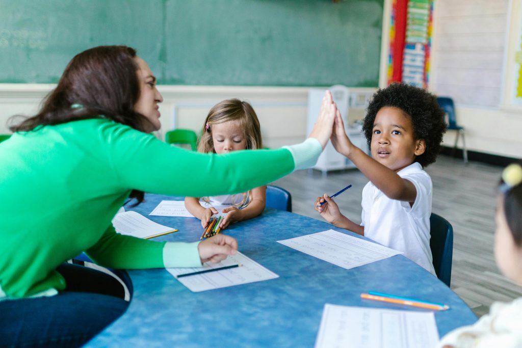 pexels photo 8363771 8363771 A teacher and students enjoying a high five during a classroom learning activity.